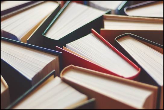 Close-up of hardbound books in various colors standing vertically shot from above